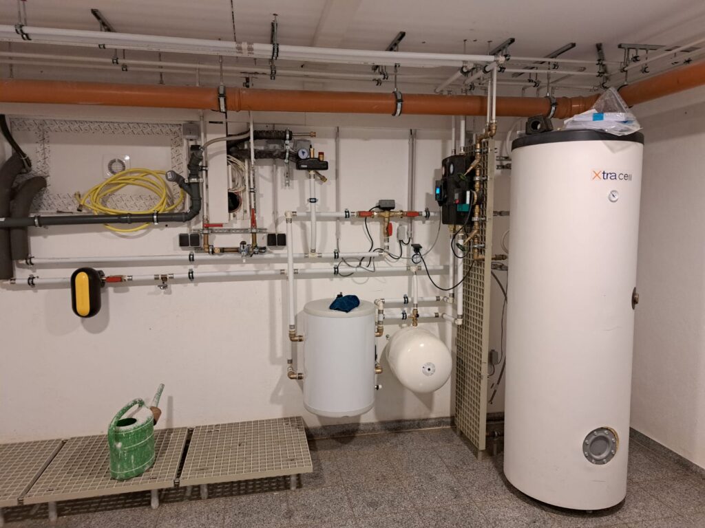 Heizungsraum mit Warmwasserspeicher und Rohrinstallation