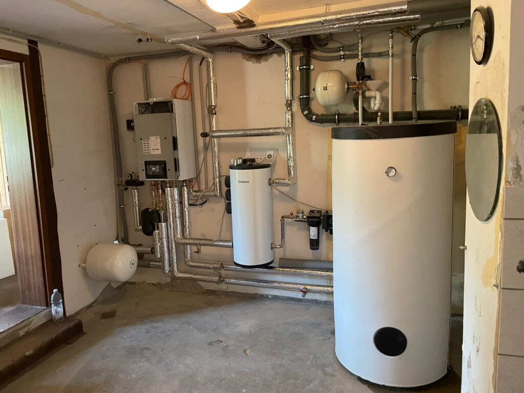 Installierte Heizungsanlage und Warmwasserspeicher im Technikraum